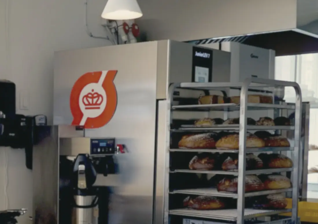 Hæveskabet bag disken med det røde Ø, kaffebryggeren og reolen med brød