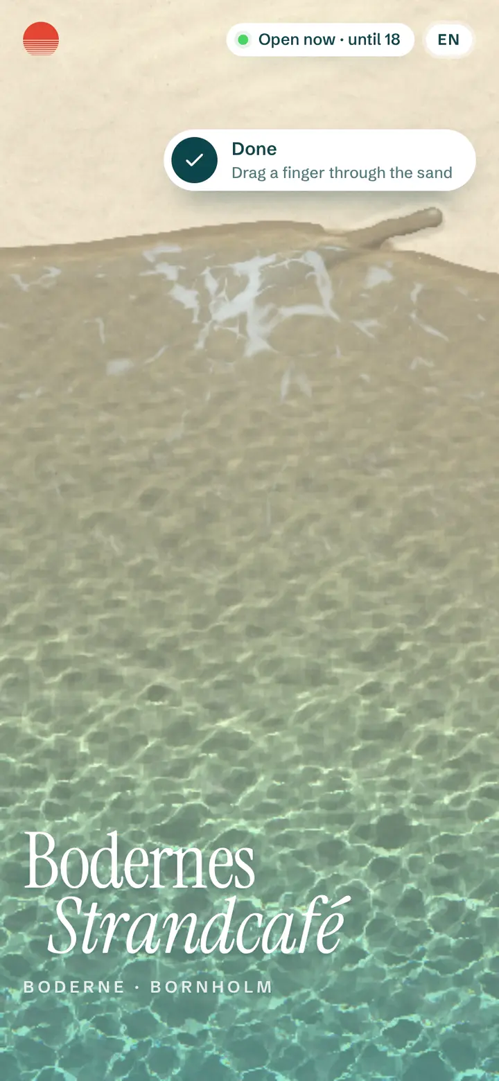 The café's site on a phone: the beach from above, the sea running up the sand, the name in a serif.