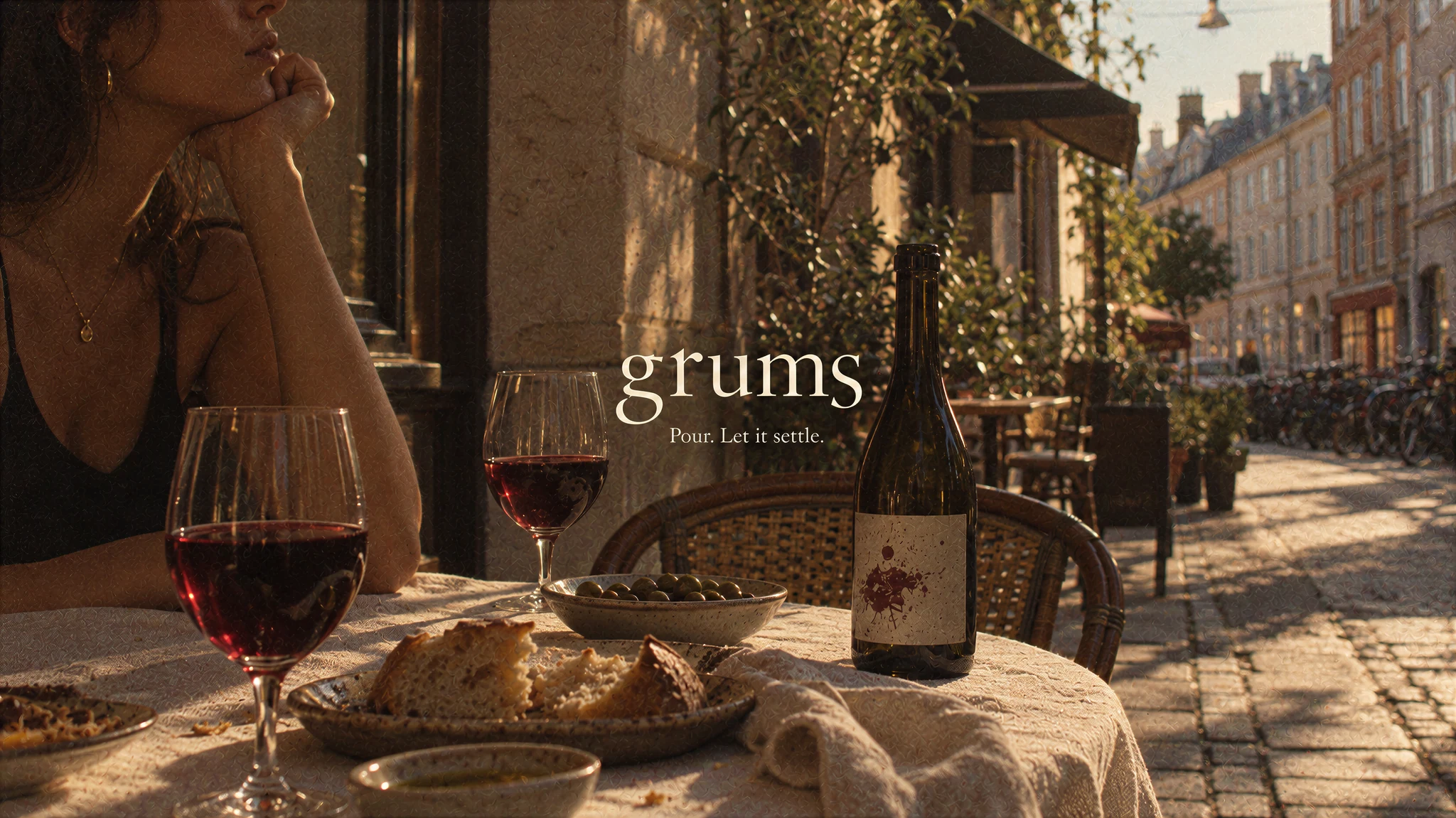 Grums café concept: wine and olives on a sunlit table beside a Copenhagen street